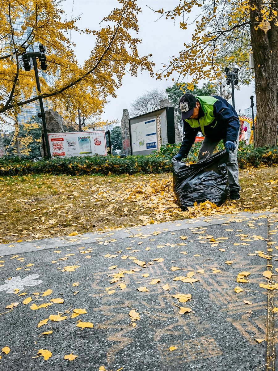 a man is picking up leaves from the ground
